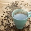Blue cup of coffee with beans around it on a burlap sack india malabar monsooned smooth